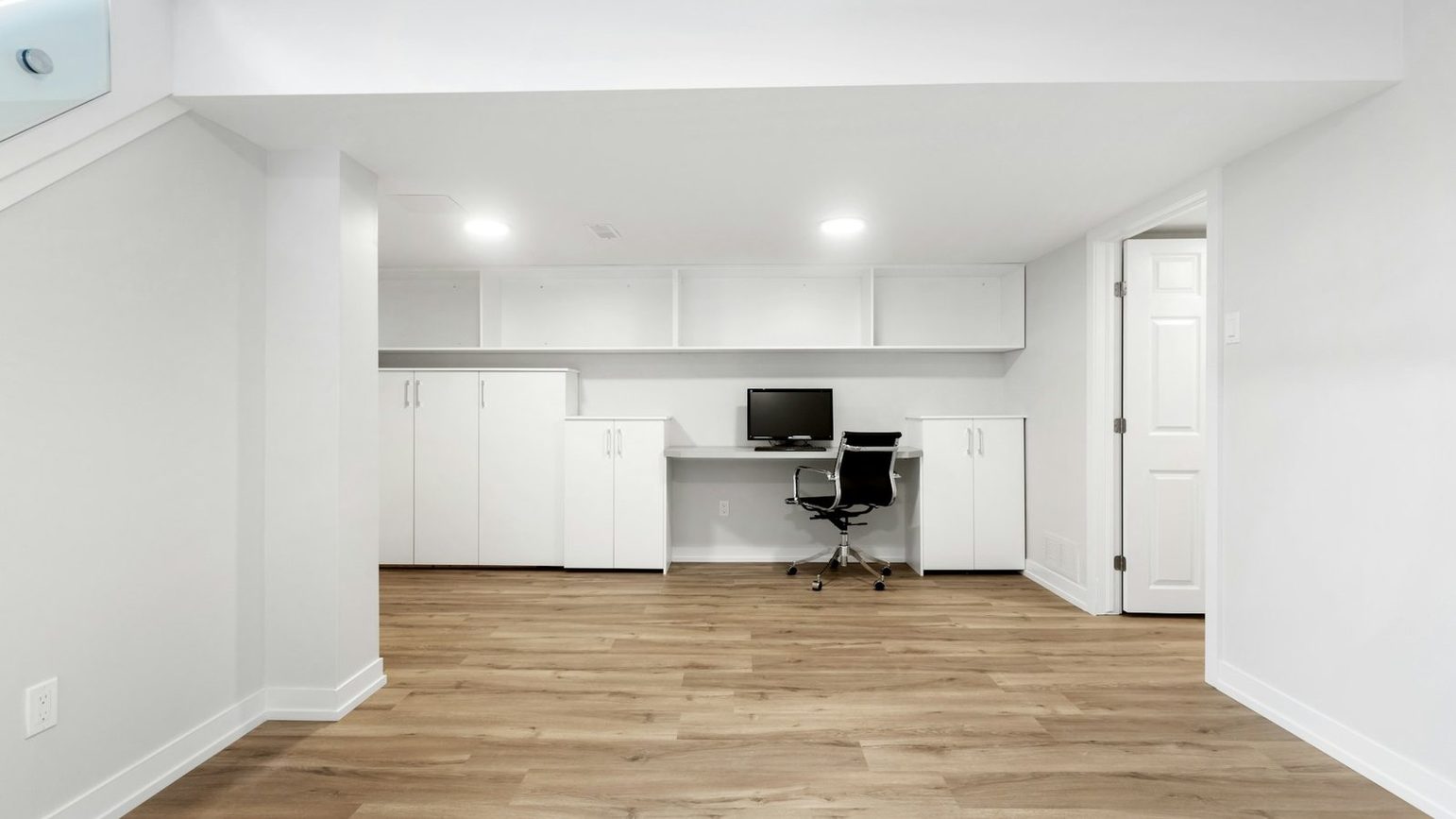 The same kind of room emptied and swept, down to bare floor and clear built-in shelving