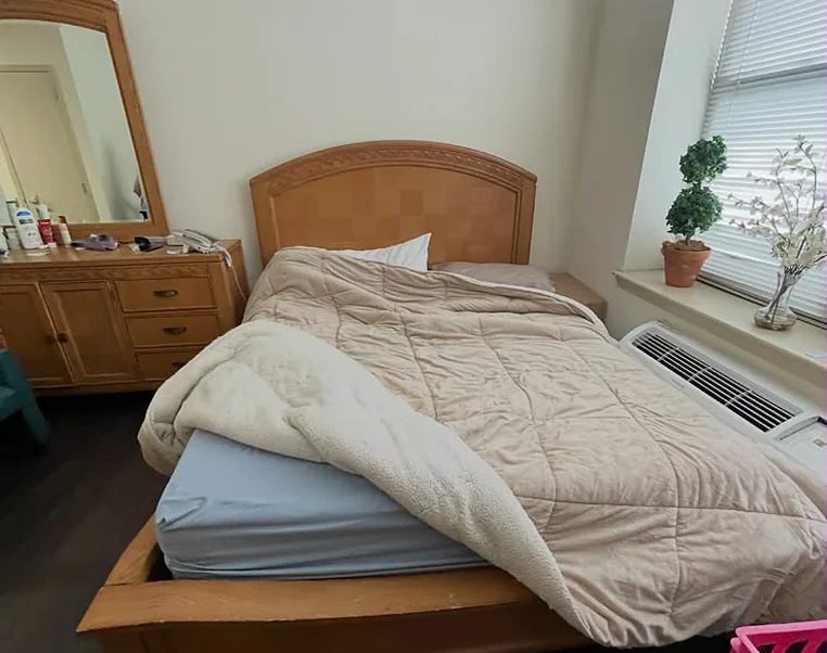 A bedroom of furniture, bedding and household contents waiting to be cleared out of a home