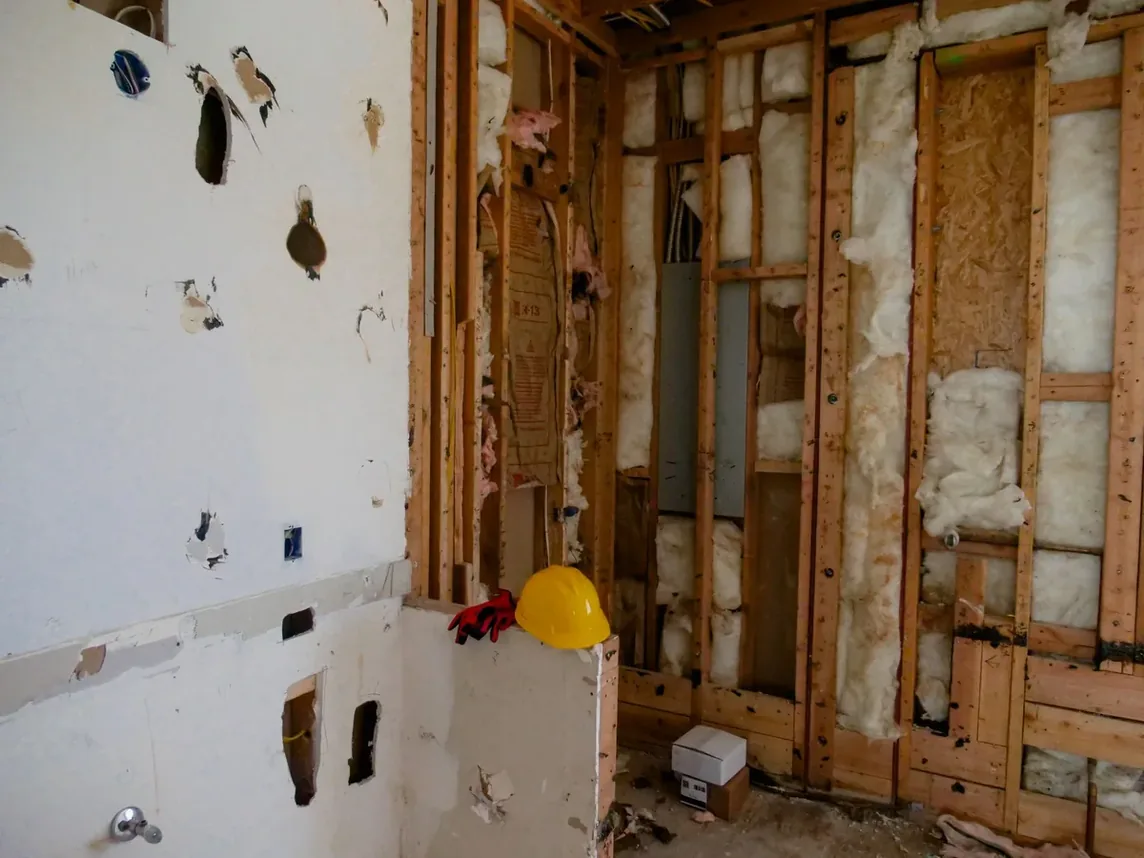 A gutted interior stripped back to studs and insulation during a home renovation