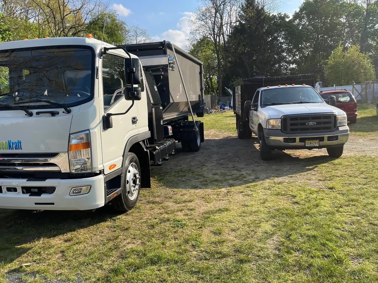 Two NJ Indoor Outdoor trucks parked and loaded at the end of a job