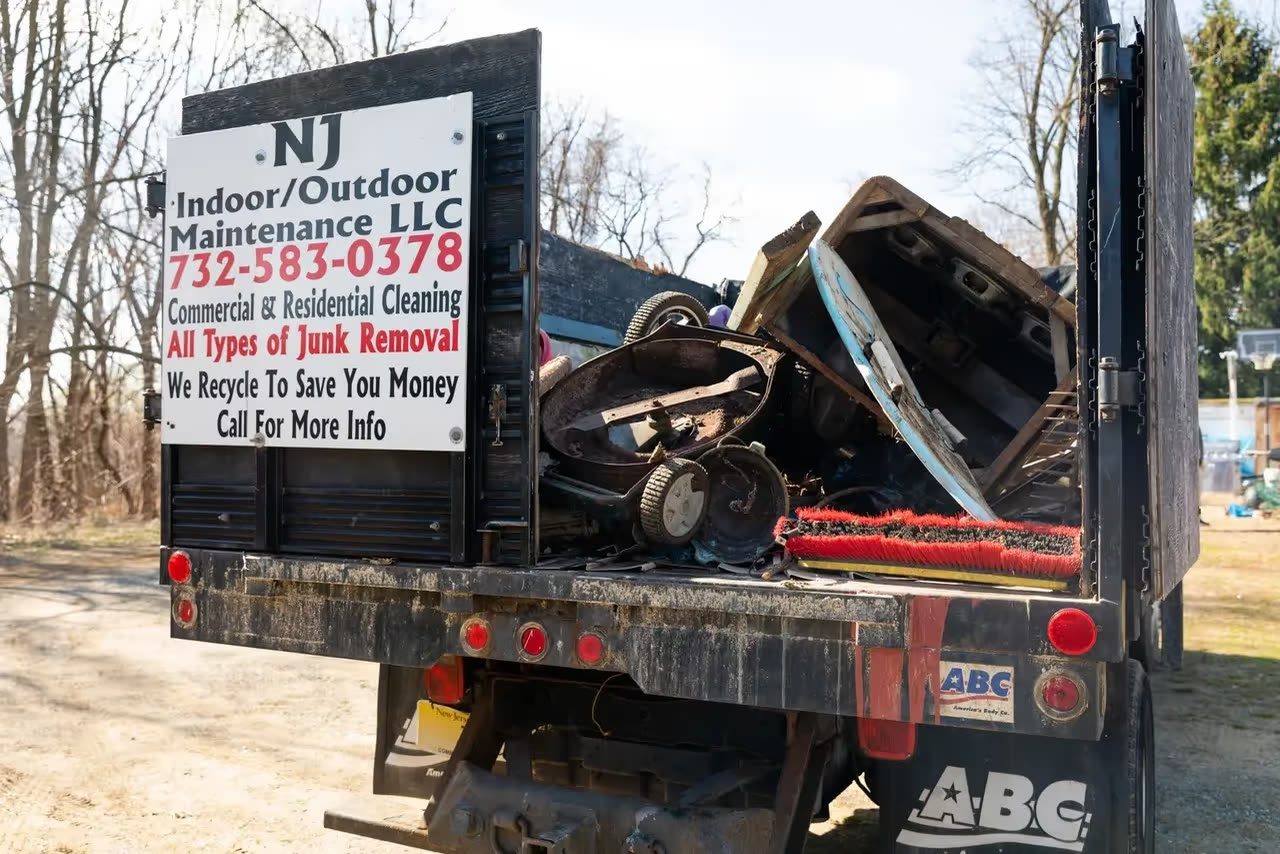 A dump truck loaded with scrap metal and old furniture from a residential junk removal job